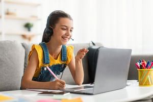 Photo of teenage girl smiling and participating in Williamsburg live online class