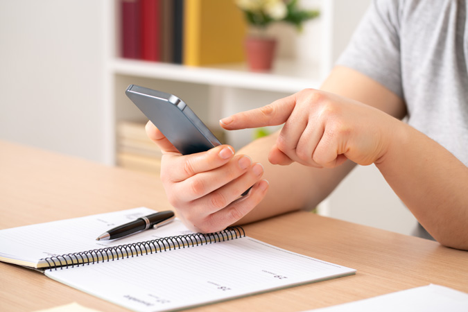 Student on their phone and using a calendar